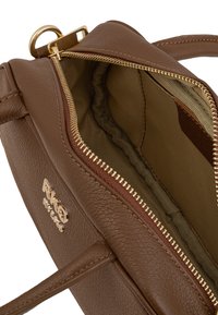 Borsa a mano in pelle marrone con zip e dettagli in oro. L'interno presenta una fodera texturizzata e una piccola tasca.