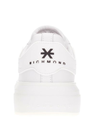 Baskets blanches vues de l'arrière avec le texte « RICHMOND » en noir et un logo en forme d'étoile noir sur l'étiquette du talon.