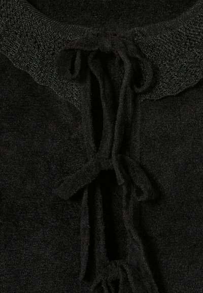 La prenda negra de punto presenta un cuello texturizado con cierre de lazo, hecha de una tela suave, mostrando una superficie oscura uniforme.