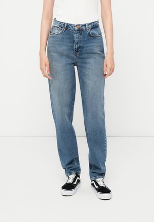 Lyseblå denim jeans med høy midje, rett benpassform, fem-lommers design og subtile slitasjer. Kombinert med svarte og hvite joggesko.