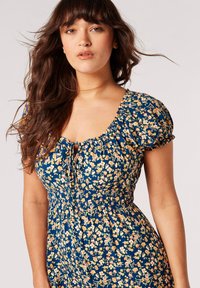 Blumen Kleid aus leichtem Stoff; hat einen marineblauen Hintergrund, ein farbenfrohes Blumenmuster, einen quadratischen Halsausschnitt und Puffärmel.