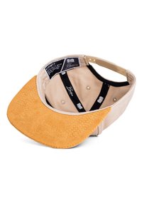 Cappello beige con una morbida visiera in suede color tan. L'interno presenta una fodera in tessuto nero con un motivo sottile. Le etichette sono visibili all'interno.