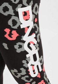 Svarte leggings med et leopardmønster i grått og rosa, med et tydelig hvitt logo på siden. Myk, elastisk stoff.