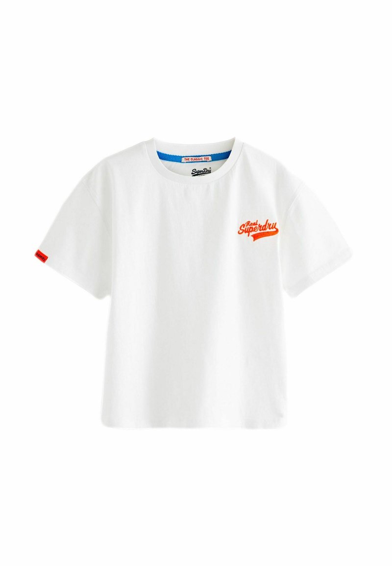 Camiseta de algodón blanca con cuello redondo, mangas cortas, que presenta un logotipo bordado naranja en el lado izquierdo del pecho y una etiqueta roja en la manga.