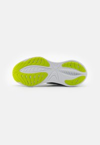 Suola della scarpa con una base bianca e motivi e scanalature in gomma verde per una migliore aderenza. Texture liscia con un design arrotondato.