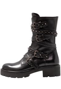 Czarny skórzany botek do kostki z wieloma paskami z ćwiekami, srebrnymi okuciami i masywnym obcasem. Gładkie wykończenie i teksturowane detale po bokach.