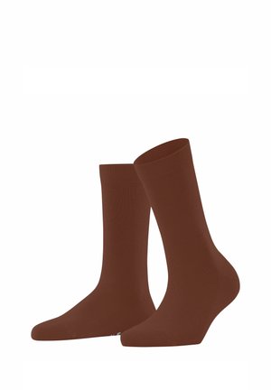 Chaussettes en coton marron avec une texture lisse, des poignets côtelés et une longueur mi-mollet, positionnées à la verticale pour mettre en valeur leur forme et leur design.