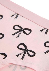 Svetle růžová látka s hladkým povrchem, s opakovanými černými potisky mašliček a kontrastním růžovým pasem.