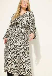 Lange, loszittende jurk met een V-hals, zwart en beige zebra print, lange mouwen, gathered taille en vloeiende gelaagde zoom.