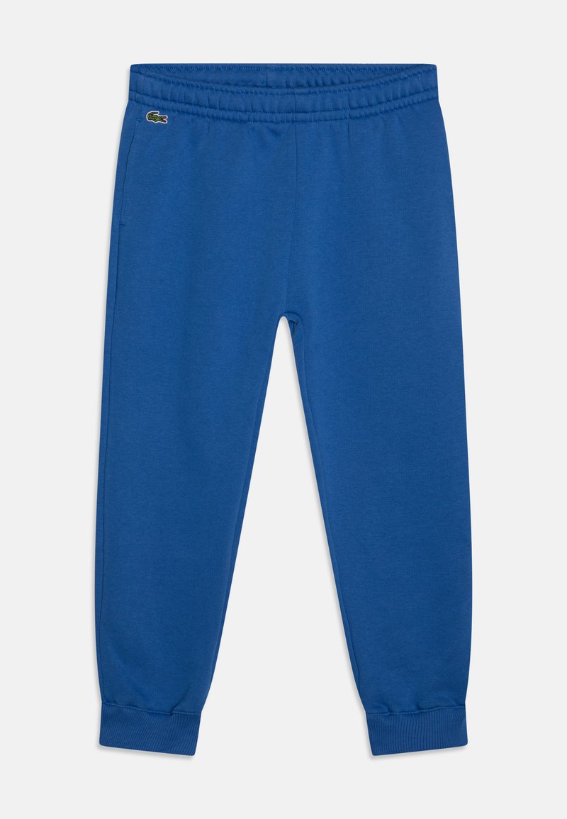Pantalons de survêtement en coton bleu avec taille élastique, poignets effilés et détail logo brodé. Texture lisse et design décontracté.
