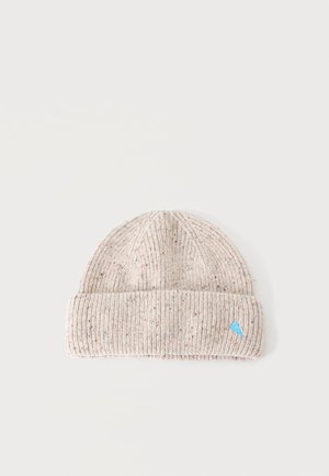 Bonnet en maille côtelée beige clair avec de petites taches multicolores et un bord replié avec un logo triangulaire bleu.
