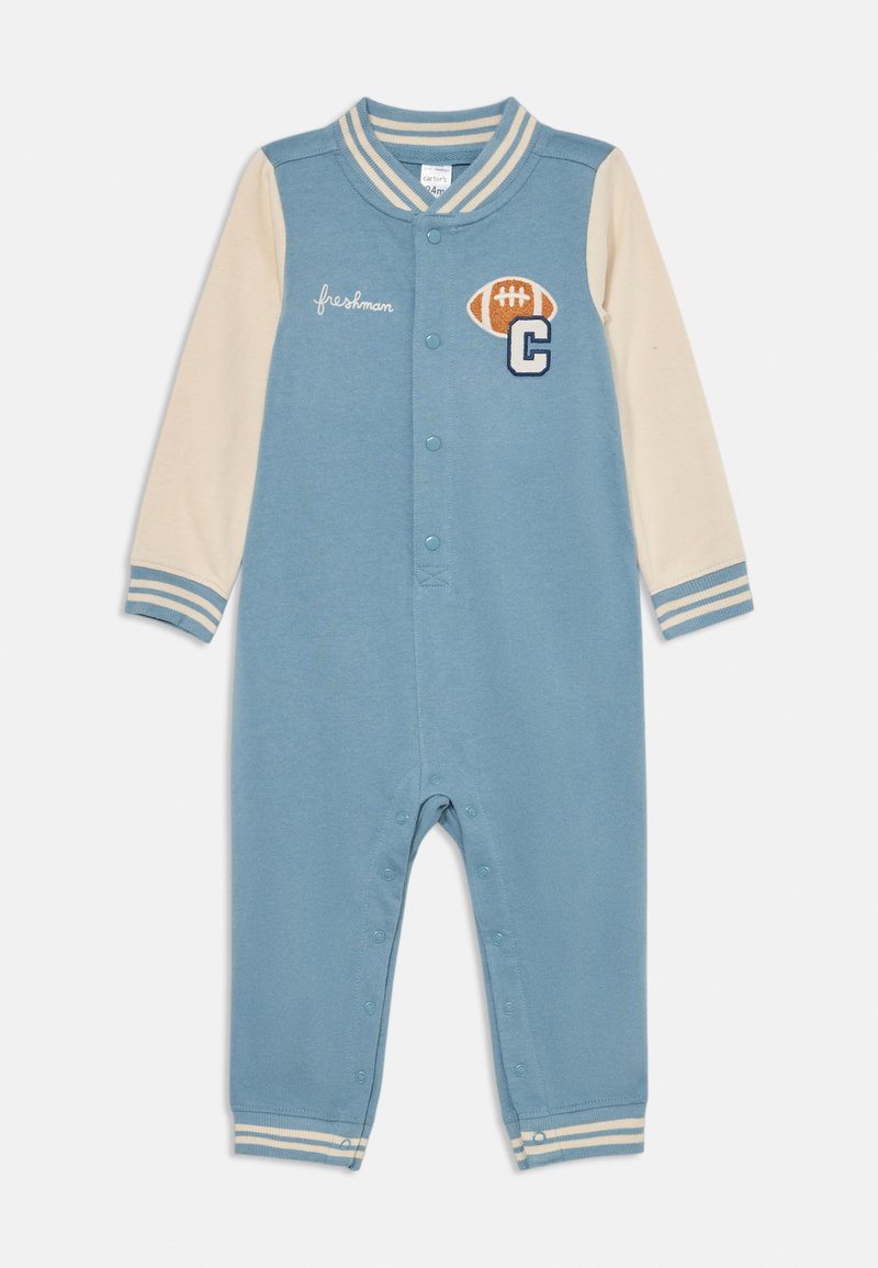 Combinaison une pièce bleu clair avec des manches crème et des poignets rayés. Présente un graphique de football et un détail brodé « freshman ». Fermetures à pression.
