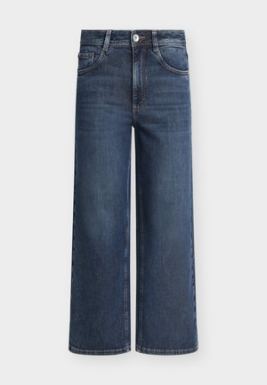 Jean en denim bleu foncé à jambes larges avec boutons et fermeture éclair à l'avant, passants pour ceinture, et poches avant sur fond uni.