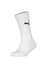 Vit idrottssocka med ribbad struktur, förstärkt tå och en svart Puma-logotyp på sidan. Standard längd för ankelsockor.