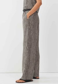 Brede broek in een zwart-wit ruitpatroon, met zijzakken, een gladde textuur en een aansluitende tailleband met een riem.