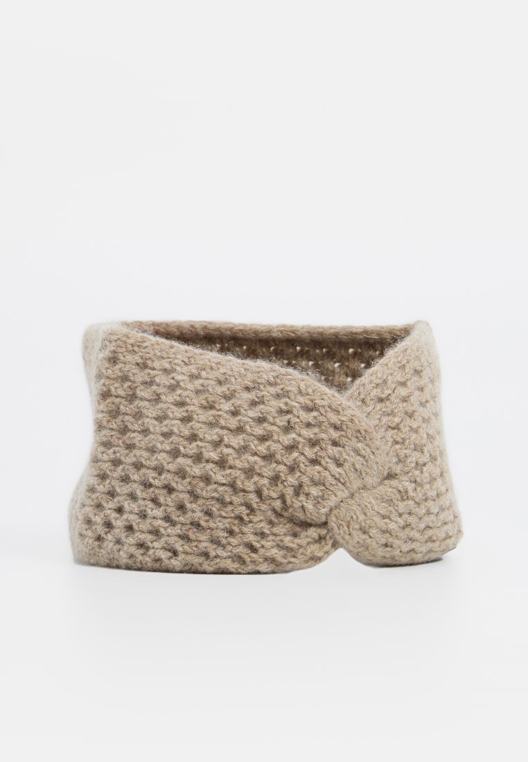 Beige gestricktes Haarband mit einem verdrehten Vorderteil, aus weichem Stoff hergestellt. Texturierte Oberfläche mit einem gemütlichen Aussehen.