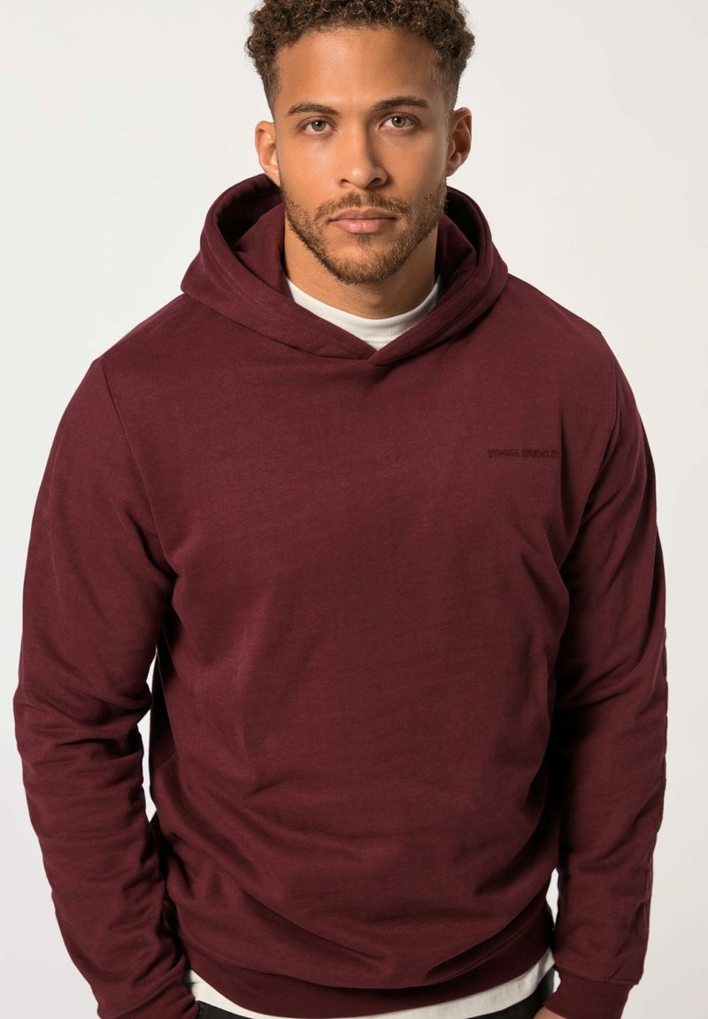 Felpa con cappuccio color bordeaux realizzata in tessuto morbido, con tasca frontale e logo ricamato sul petto. Il design è comodo e alla moda.