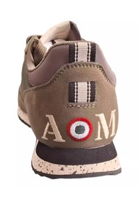Sneaker in suede verde oliva con colletto imbottito, dettagli a righe nere e bianche, e lettere bianche ricamate "AOM" con un design circolare.