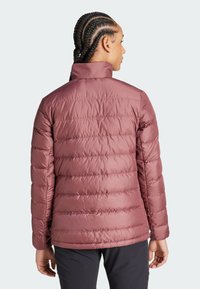 Herrens vadderad jacka i mauve färg, med hög krage, kviltat mönster och elastiska ärmslut, med en mjuk, glänsande textur.