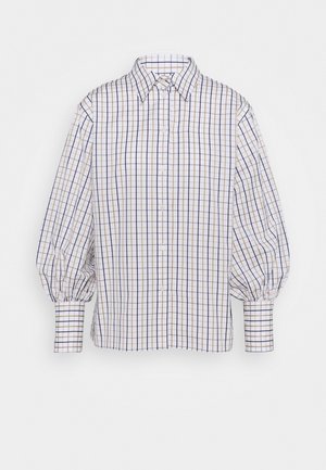 Chemise blanche avec un motif à carreaux bleu et beige, manches longues bouffantes, fermeture à boutons et col pointu. Tissu texturé, coupe décontractée.