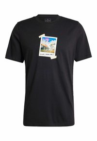 T-shirt en coton noir avec un imprimé de paysage montagnard coloré, bordé de blanc et avec des bords à l'avant central. Manches courtes.