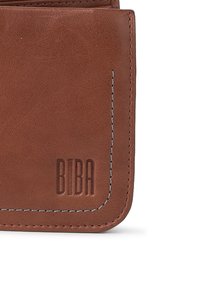 Portefeuille en cuir marron avec des coutures contrastées, présentant un logo en relief. Le design est rectangulaire avec des bords arrondis et une texture lisse.