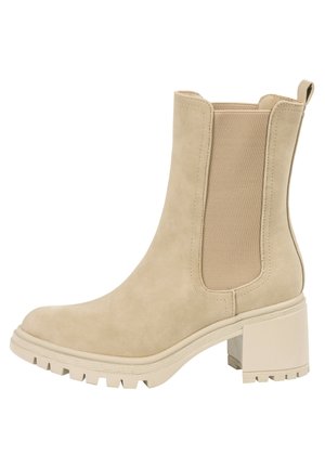 Beige ankelstøvle med elastisk sidestykke, chunky blokhæl og tyk rillede sål for ekstra greb.