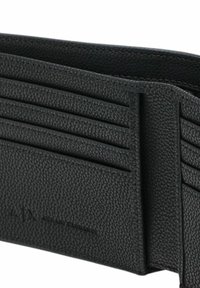 Billetera de cuero negro con superficie texturizada, que cuenta con múltiples bolsillos para tarjetas y logotipo grabado. Diseño compacto sin hardware adicional.