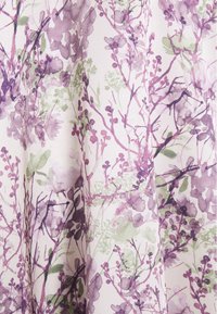 Tissu à motif floral aux teintes douces de violet et de vert sur un fond blanc. Effet aquarelle texturé avec des formes de feuilles variées.