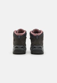 Svarte tursko med grå teksturoverflate, rosa mesh-innebygd, og slitesterk svart gummisåle. Funksjoner inkluderer en pull-tab og glidelås.