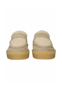 Beige suede slip-on shoes with thick gum soles and fluffy shearling lining visible on top, shown from front on white background.