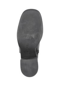Suela de zapato de goma negra con superficie lisa, bordes ligeramente elevados y base de tacón rectangular. Marcas de la marca y el tamaño visibles.