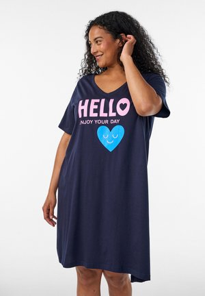 Femme aux cheveux bouclés portant une robe bleu marine avec un texte rose "HELLO Enjoy your day" et un cœur bleu souriant à l'avant.