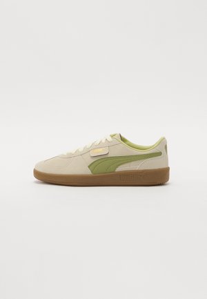 Sneaker Puma beige e verde, modello basso, con suola marrone, logo laterale e lacci crema, mostrato di profilo su sfondo bianco semplice.