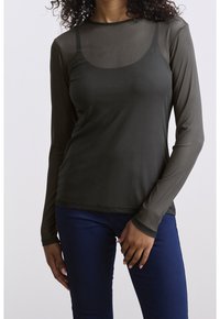 Haut à manches longues vert olive foncé avec un panneau semi-transparent au niveau de la poitrine, col rond et silhouette ajustée. Texture lisse et détails de couture minimaux.