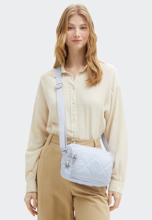 Borsa a tracolla trapuntata azzurro chiaro con logo argentato. Caratterizzata da una tracolla regolabile, tasca con zip e dettagli metallici.