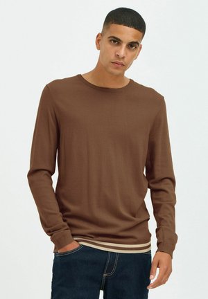Camisa marrón de manga larga con cuello redondo y puños acanalados. Presenta un dobladillo acanalado con rayas beige, fabricada en un tejido suave.