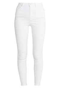 Jeans skinny de tiro alto en blanco, hechos de denim. Con bolsillos delanteros, cremallera y un acabado suave y texturizado. Talla estándar en toda la prenda.