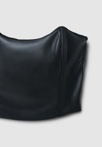 Top corto in pelle nera con una texture liscia, scollatura rotonda e design aderente. Cuciture pulite e silhouette che si adatta al corpo.