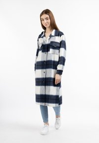 Cappotto a quadri blu navy e bianco con due tasche sul petto, maniche lunghe e taglio dritto, realizzato in tessuto morbido e texturizzato.