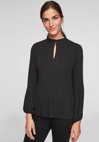 Zwarte plooiblouse met een hoge kraag, een sleutelgatopening bij de hals en lange poffende mouwen, gemaakt van lichtgewicht stof.