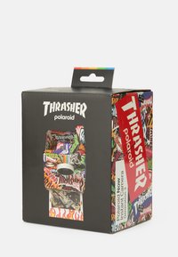 Polaroid Now kameraemballasje i svart, dekket med et livlig Thrasher-logo og grafiske mønstre som viser røde, grønne og blå accenter.