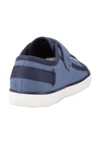 Scarpa in tela blu con cinturino in velcro, punta arrotondata e suola in gomma bianca. Presenta dettagli cuciti e un pannello laterale testurizzato.