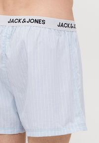 Boxers rayés bleu clair en coton, avec une taille élastique portant le logo "JACK & JONES" et une coupe décontractée pour le confort.