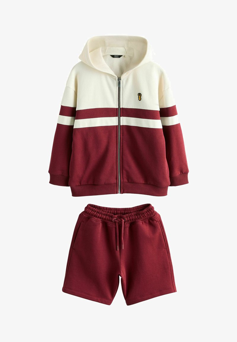 Reißverschluss-Hoodie mit cremefarbenen und kastanienbraunen Farbblöcken sowie kastanienbraune Shorts mit Kordelzugbund, passendes lässiges Freizeitoutfit.