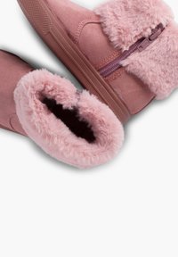 Botine roz din suede, cu guler din blană artificială, detalii cu fermoar și talpă texturată din cauciuc. Captuseală interioară moale pentru confort.