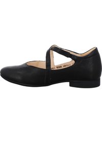 Zapato plano de cuero negro con punta redondeada, correa en el empeine y tacón bajo. Textura suave y diseño minimalista.