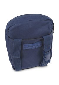 Bolsa de tela azul marino con cierre de cremallera, que presenta una superficie texturizada y una correa en la parte frontal. El logo "SKECHERS" está exhibido en la parte delantera.