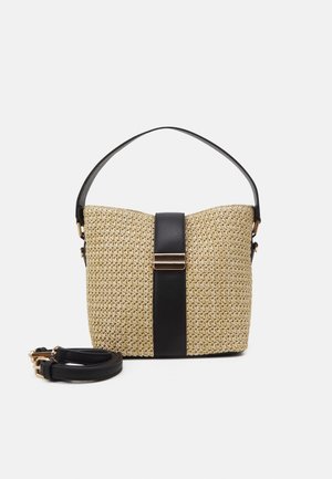 Kleine beige gewebte Handtasche mit schwarzem Lederriemen und vertikalem schwarzem Lederakzent mit goldener Schnalle, dazu ein abnehmbarer Schulterriemen daneben.