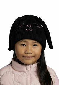 Black ribbed knit hat with bunny ears and facial embroidery in pink, worn by a child. The hat's ears hang down on either side.